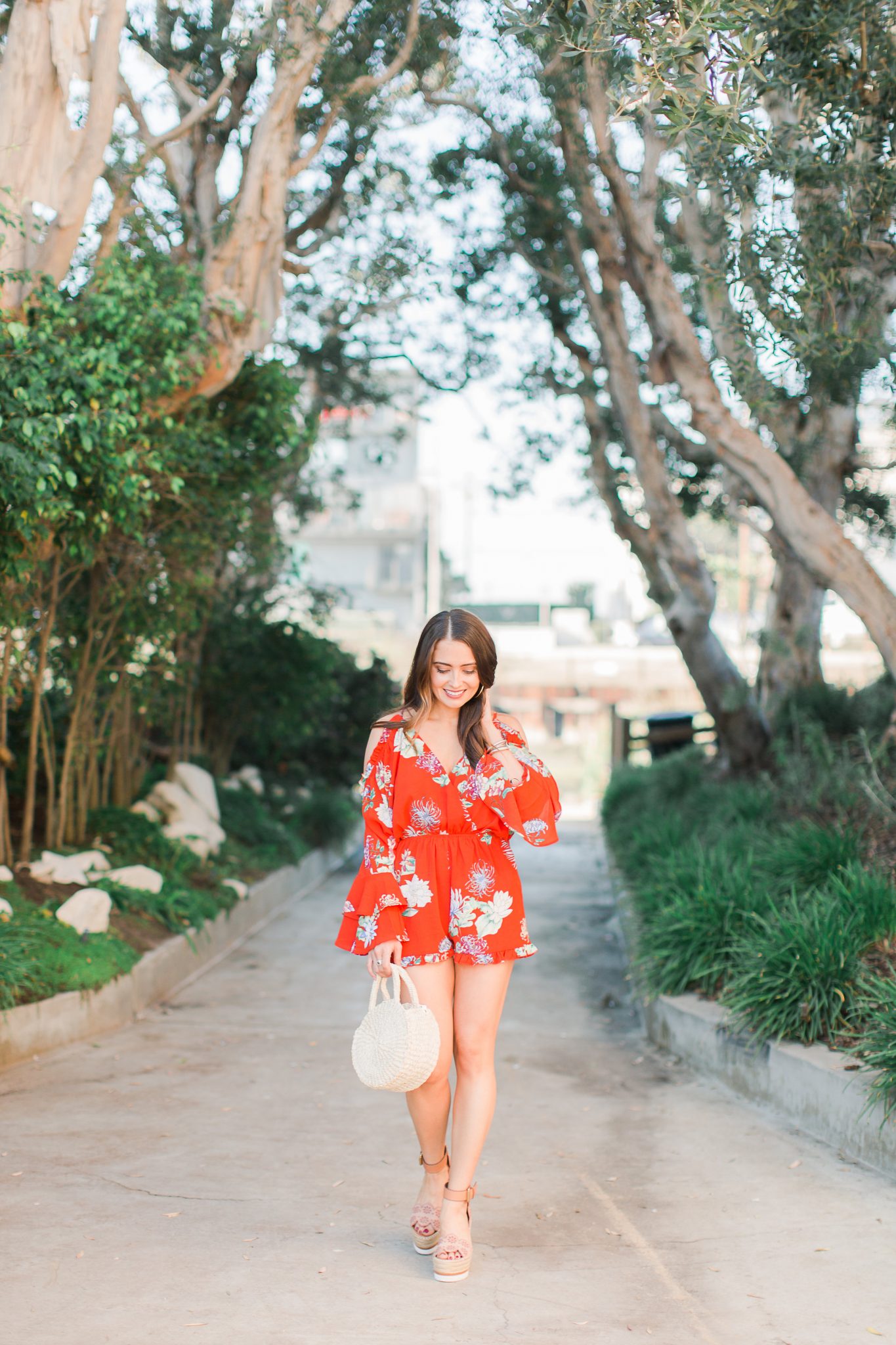red floral romper with wedges and straw bag - 3 Ways to Incorporate Florals Into Your Spring Wardrobe featured by popular Orange County fashion blogger, Maxie Elle
